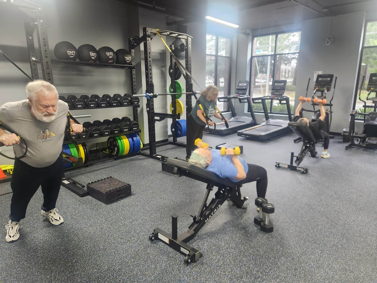 Clients using dumbbells and suspension straps in the new Sound Sports gym.